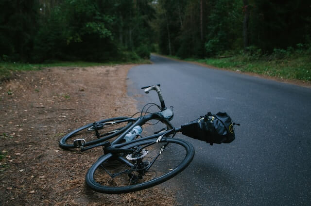 ein Fahrrad liegt am Wegesrand nach einem Unfall